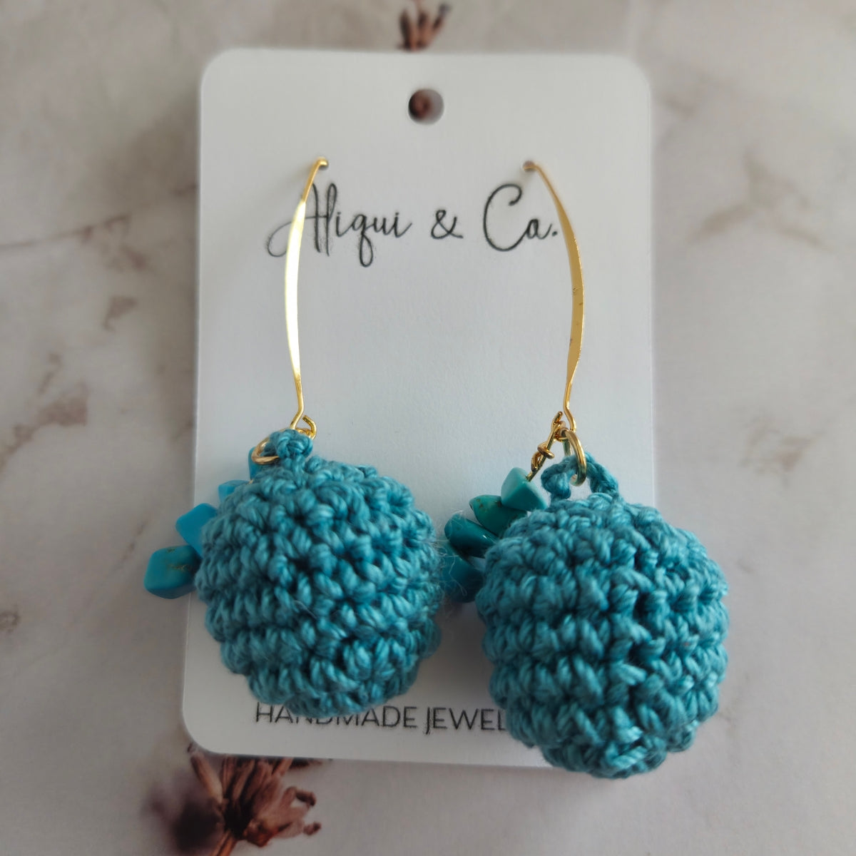 Warm teal crocheted earrings on a white card with 'Aliqui & Co.' branding