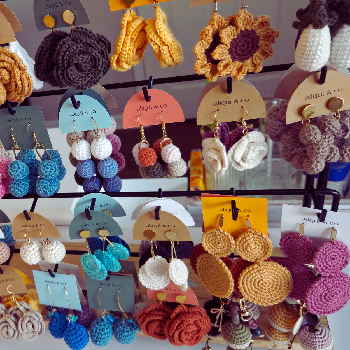A rack of crochet earrings in neutral colors