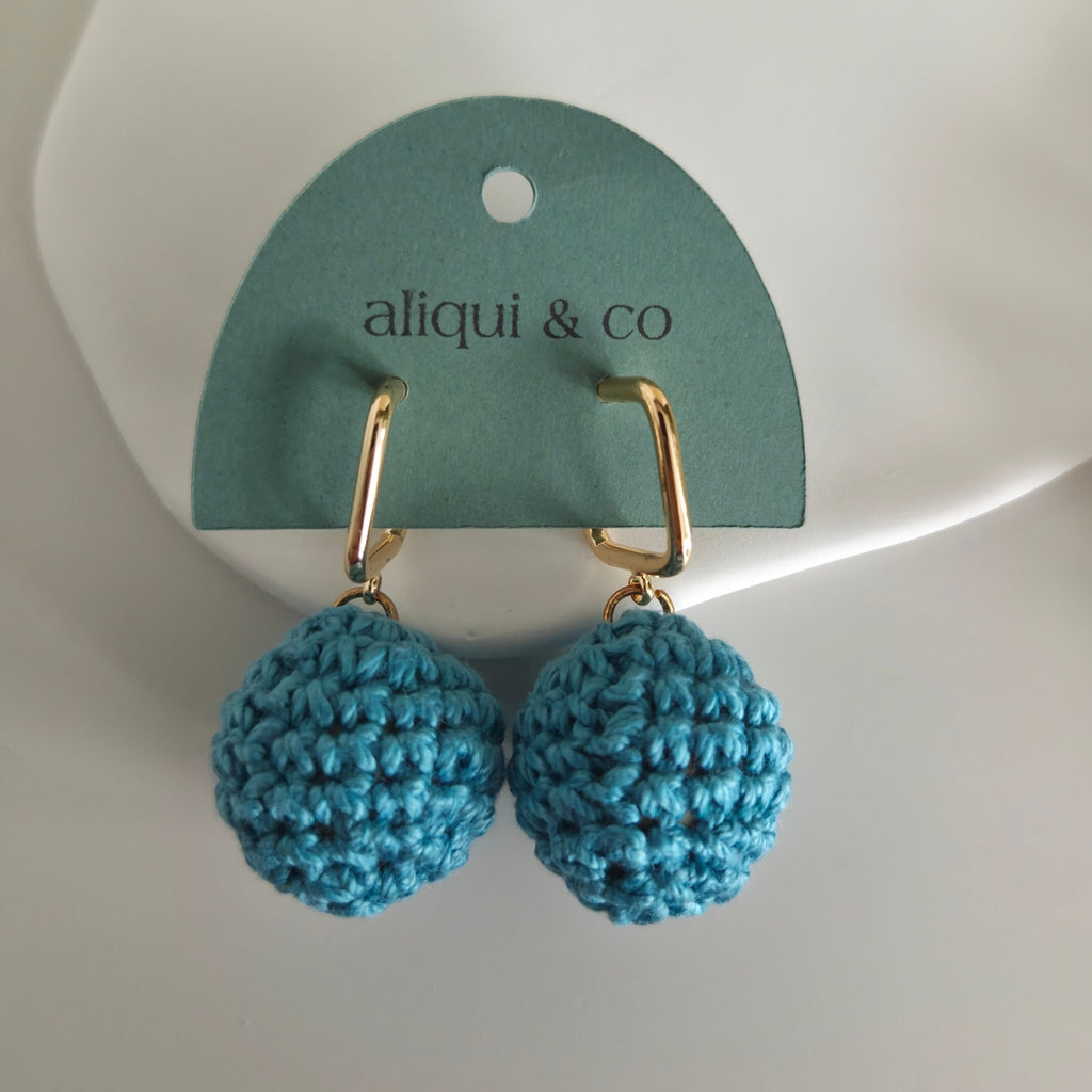 Blue crochet earrings on a 'aliqui & co' branded card against a white background