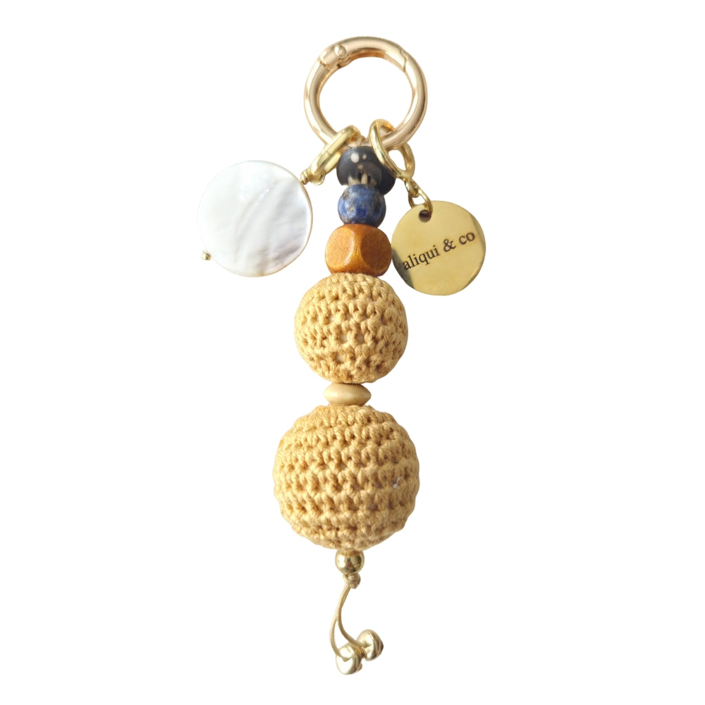 Keychain with yellow crochet beads and a gold tag on a white background