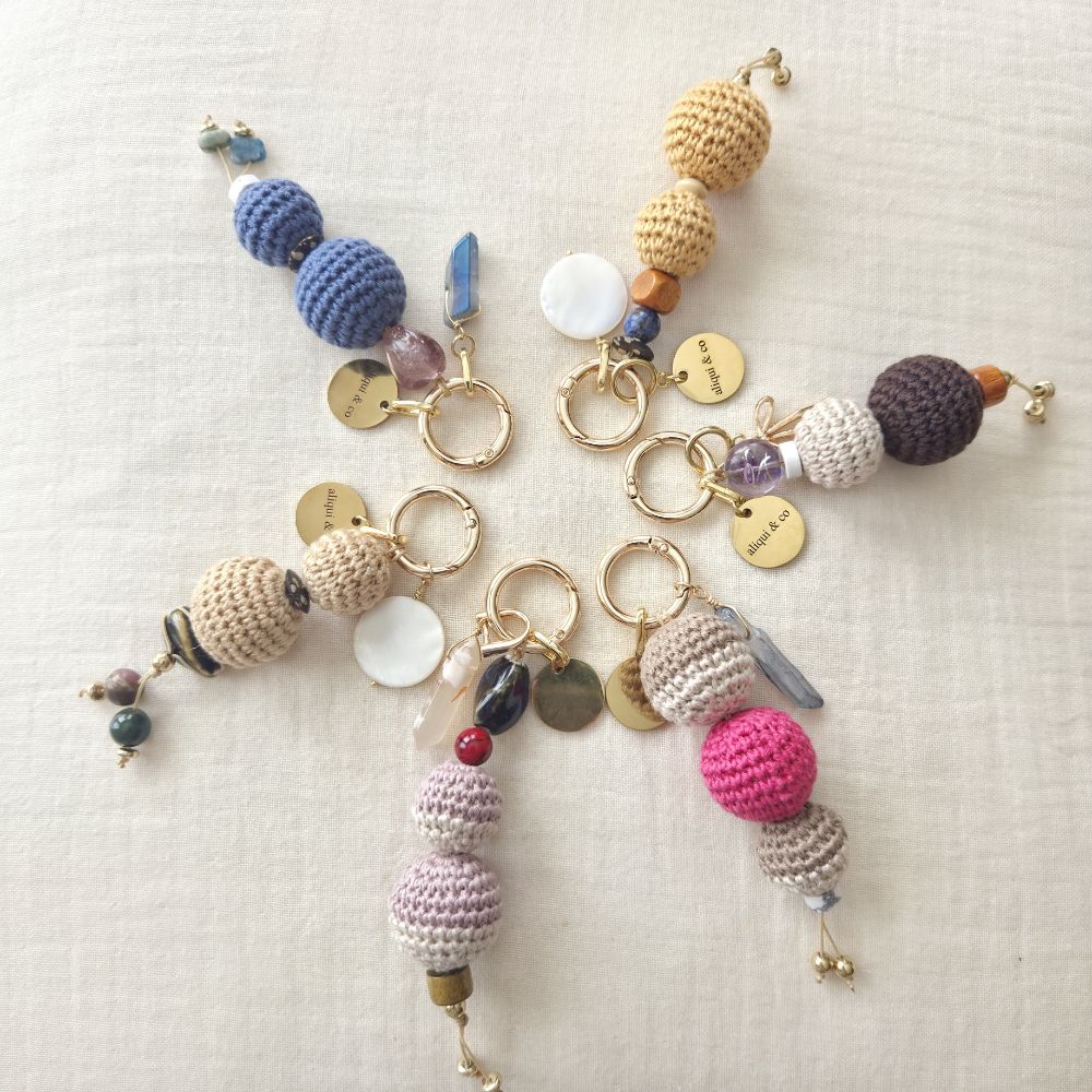 Colorful crochet beaded keychains on a textured surface