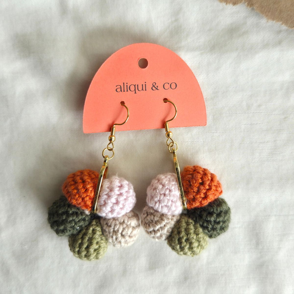 Colorful crocheted earrings on a 'aliqui & co' branded card against a white background