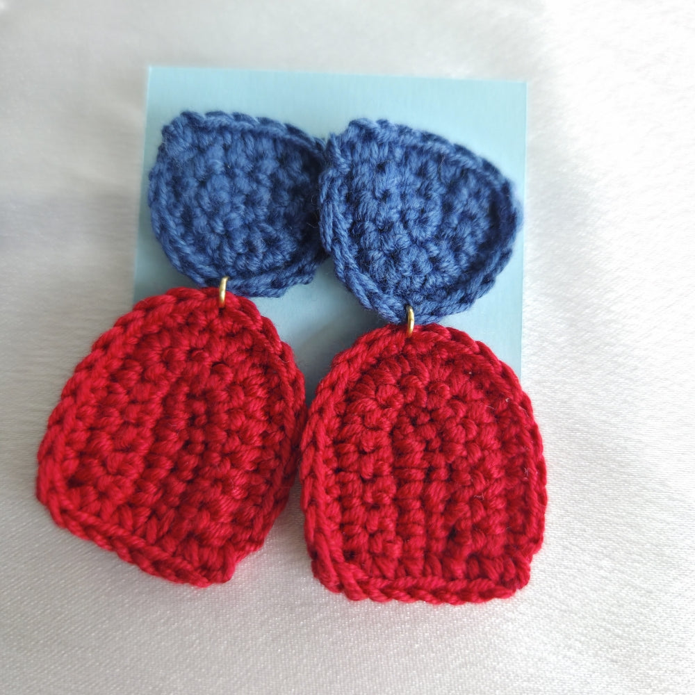Pair of red and blue boho crocheted earrings on a light blue card.