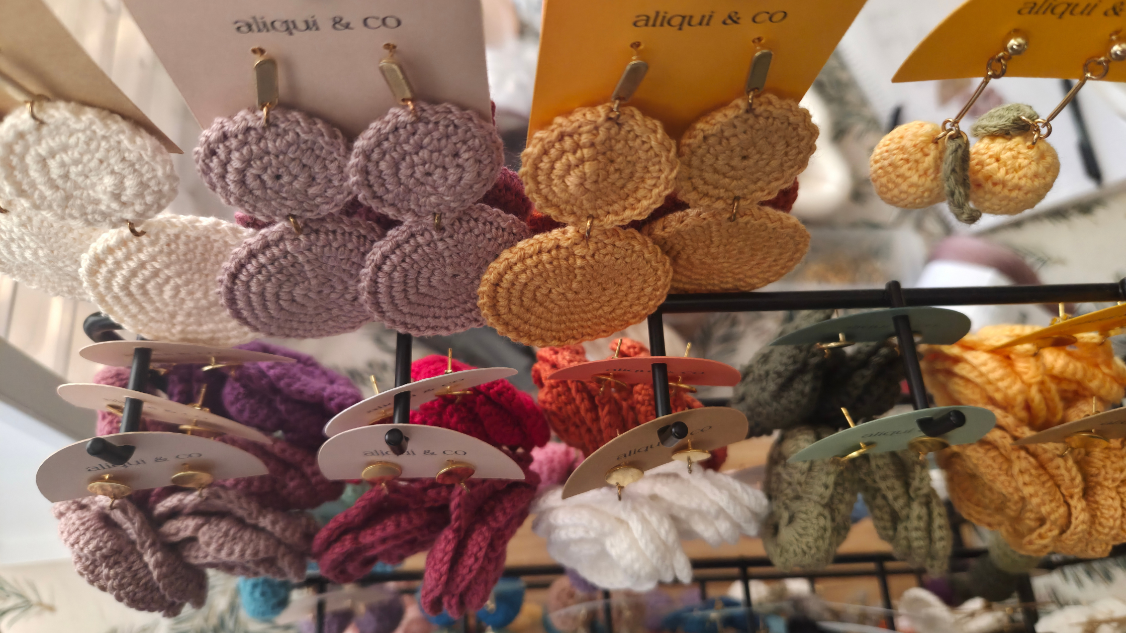 Colorful and cool handmade earrings on display with 'aliqui & co' branding.