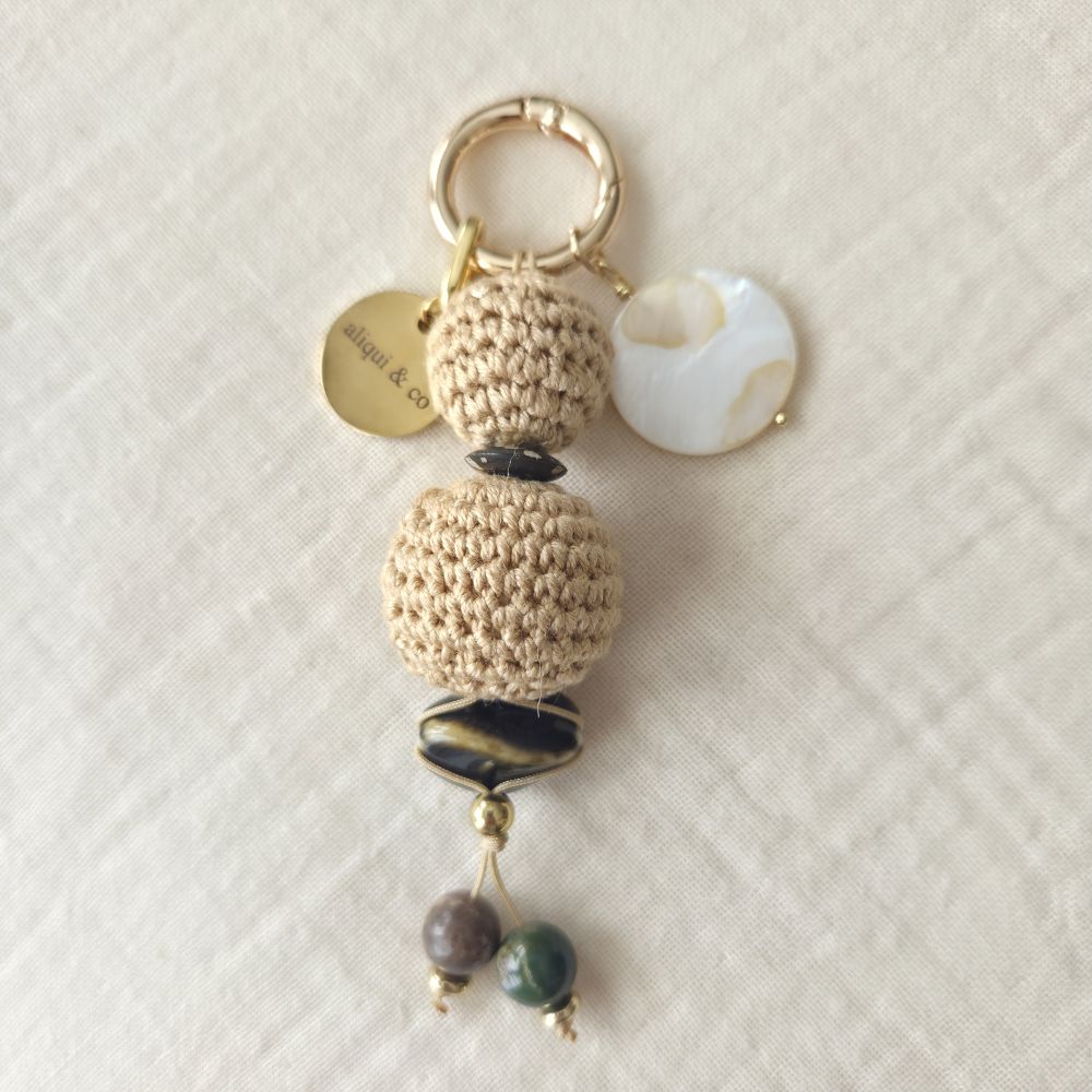 Crocheted keychain with beads on a textured white background