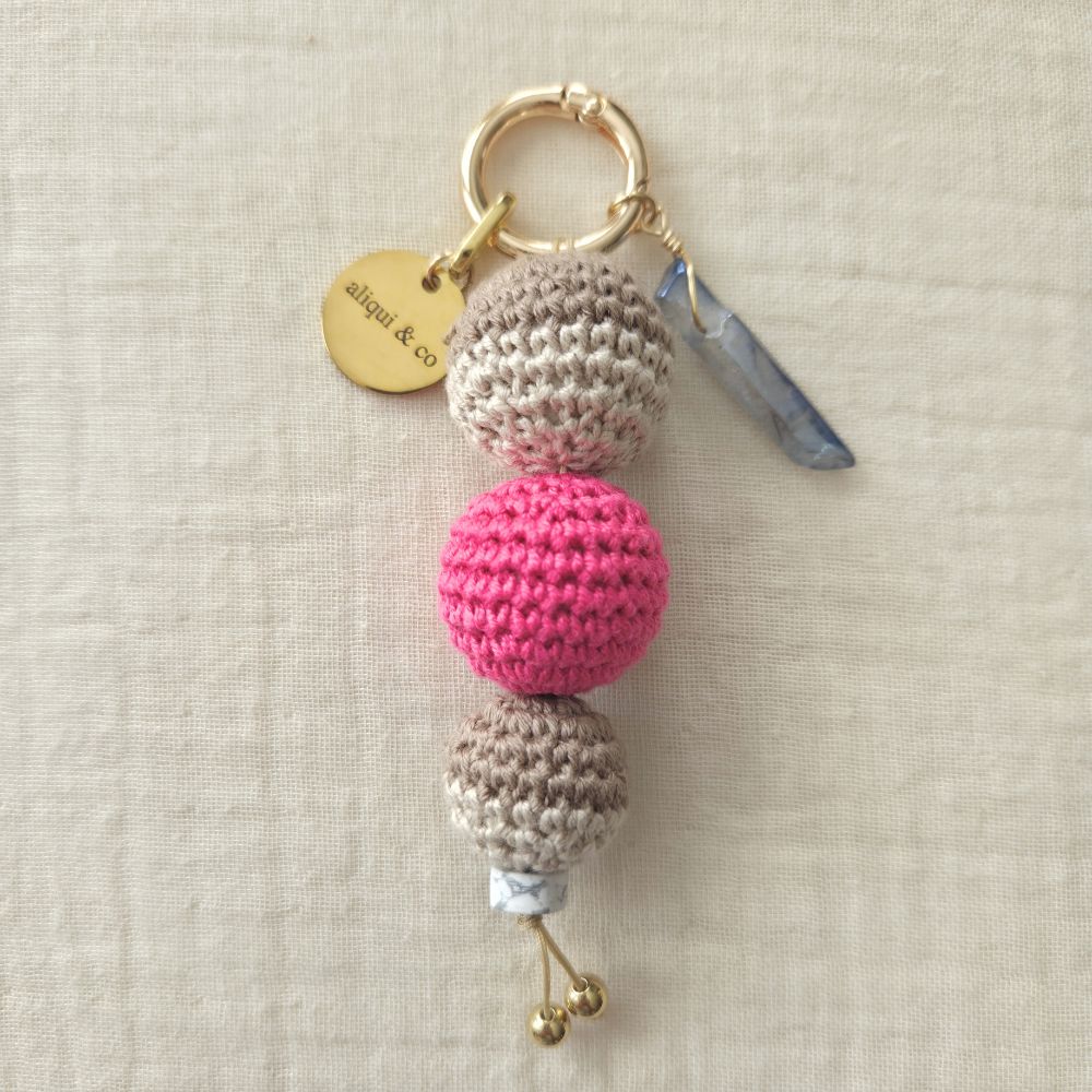 Keychain with three crocheted beads on a neutral background