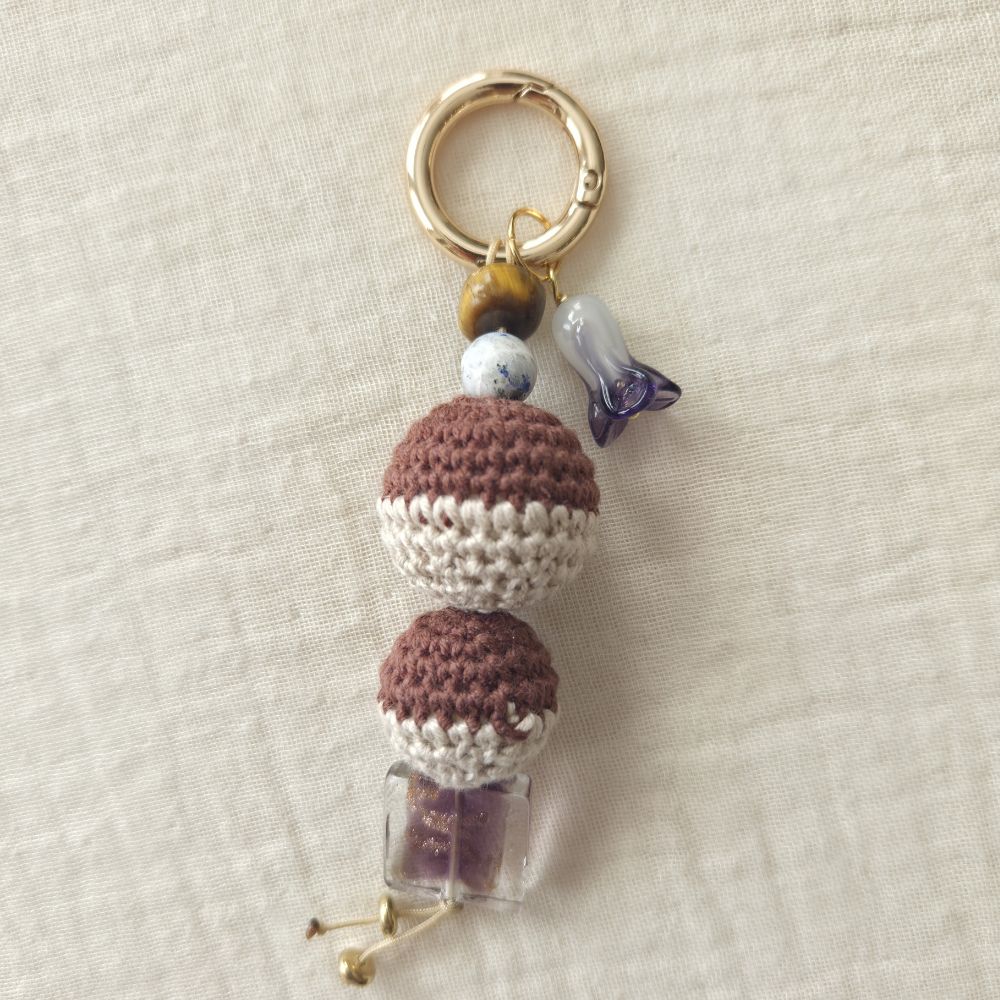 Decorative keychain with beads  on a textured beige background