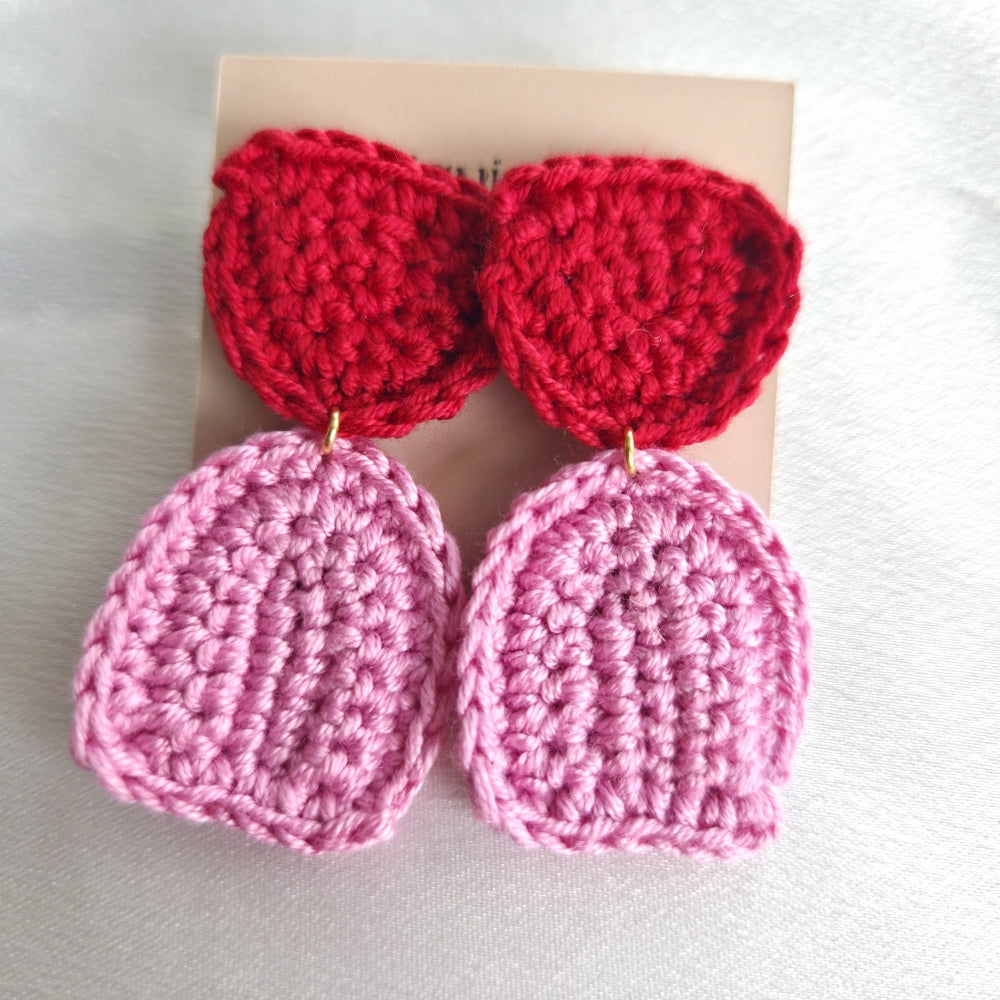 Pair of pink and red crocheted earrings on a light background