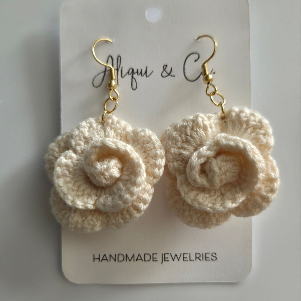 Cream crocheted rose earrings on a 'Aliqui & Co' branded card.