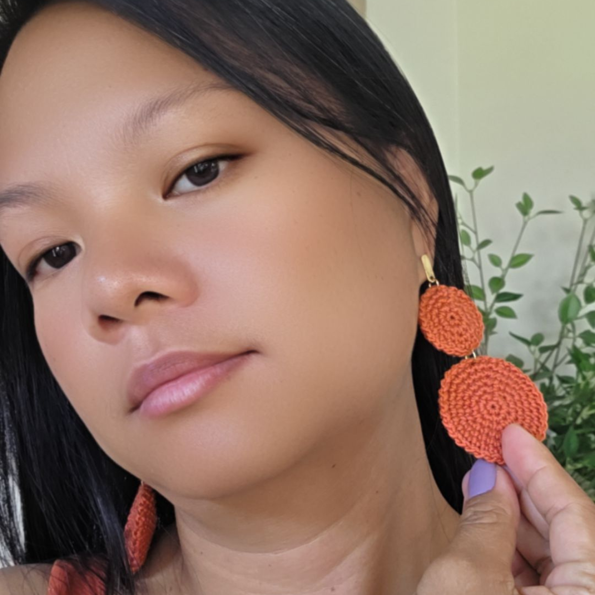 close-up photo of a woman flexing her crochet earrings boho round style.