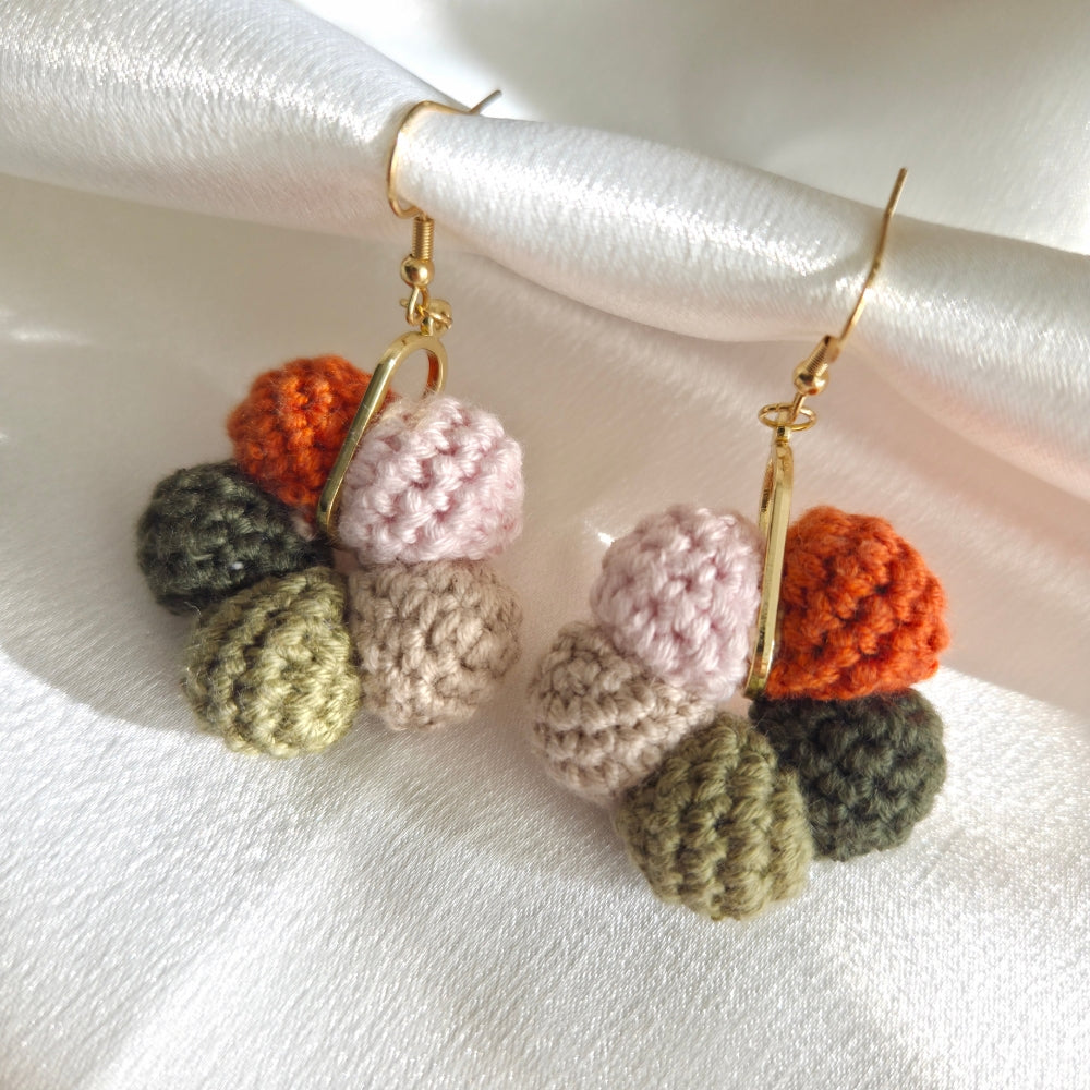 Colorful crocheted ball earrings on a white background