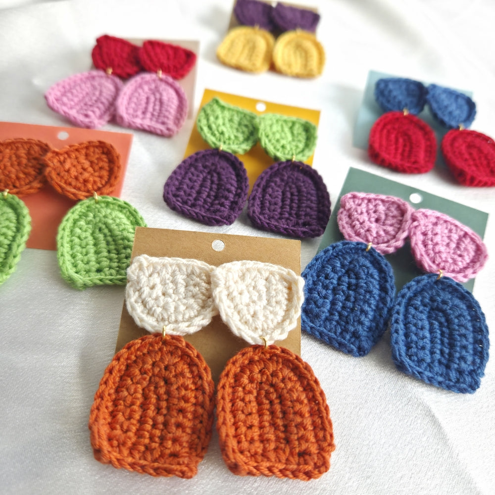 Sets of colorful crochet earrings on display in white background