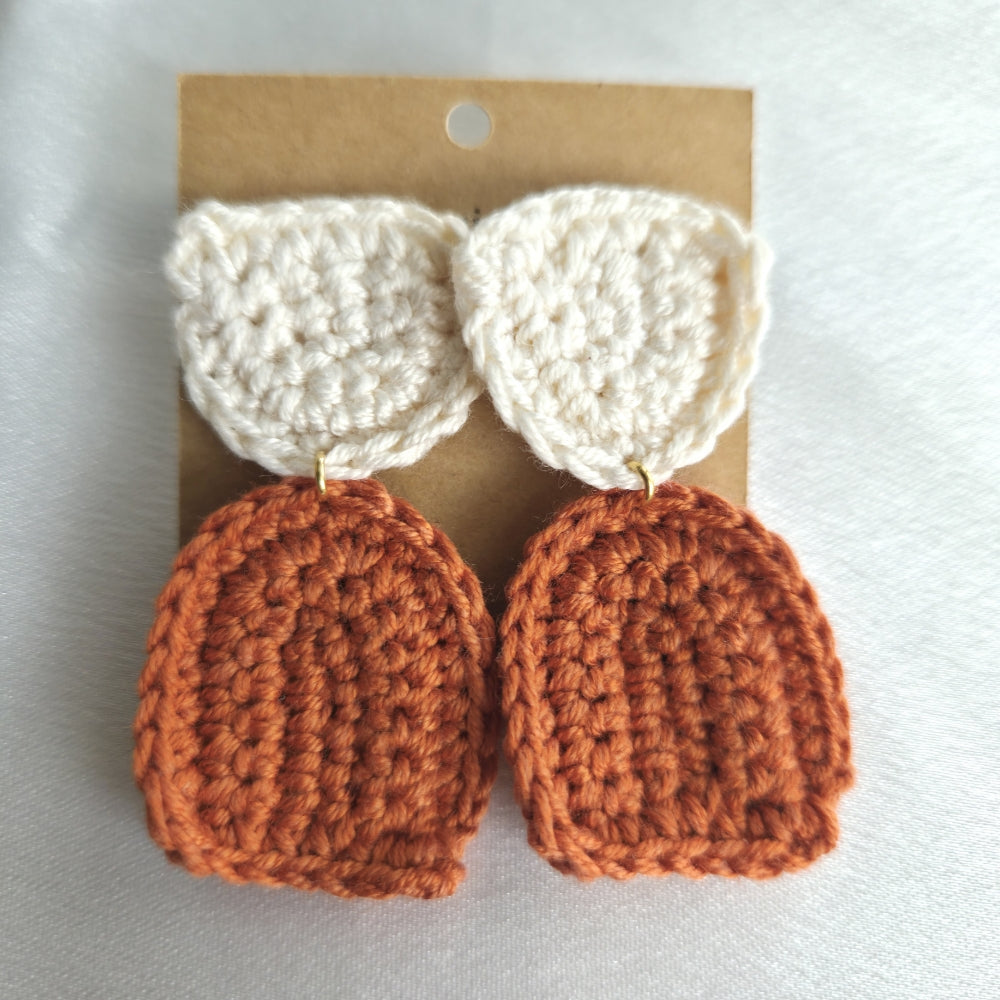 Pair of crocheted colorblock earrings on a cardboard backing with a white background