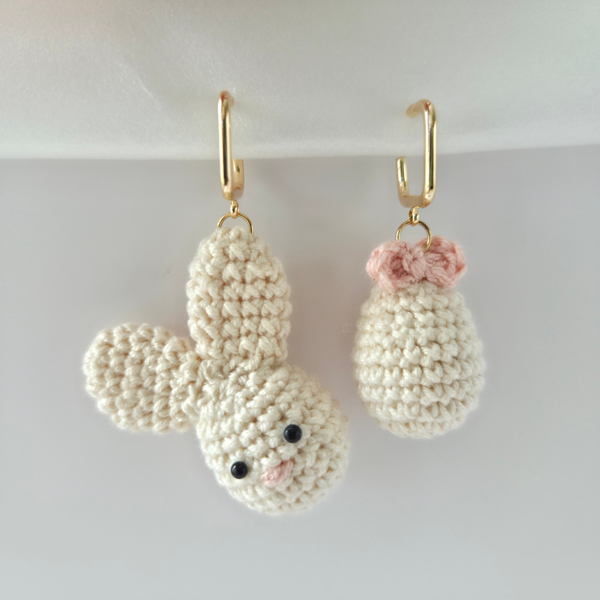 Crocheted bunny earrings and Easter egg with gold hooks on a white background