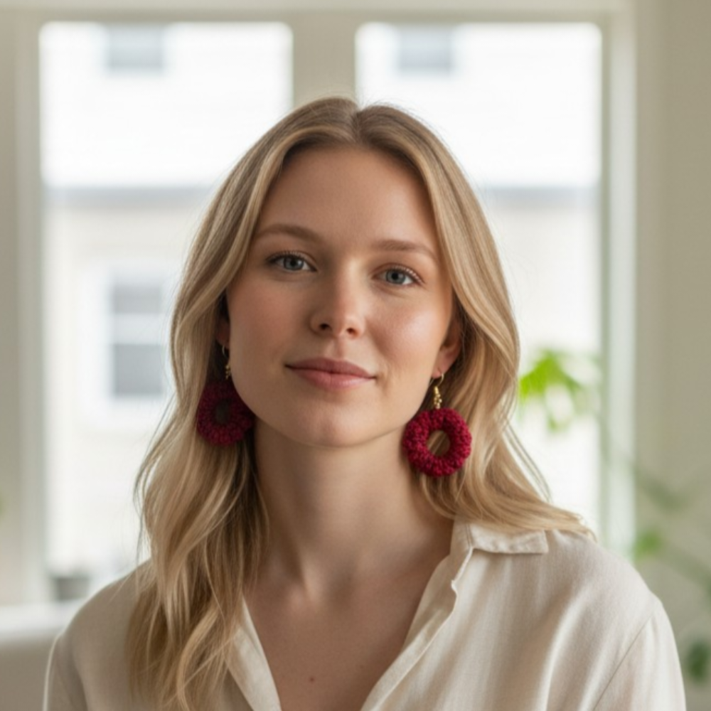 Woman wearing red earrings indoors with a blurred background