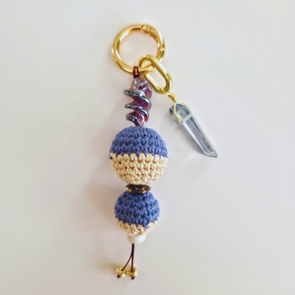 Keychain with blue and beige beads and a crystal on a white background