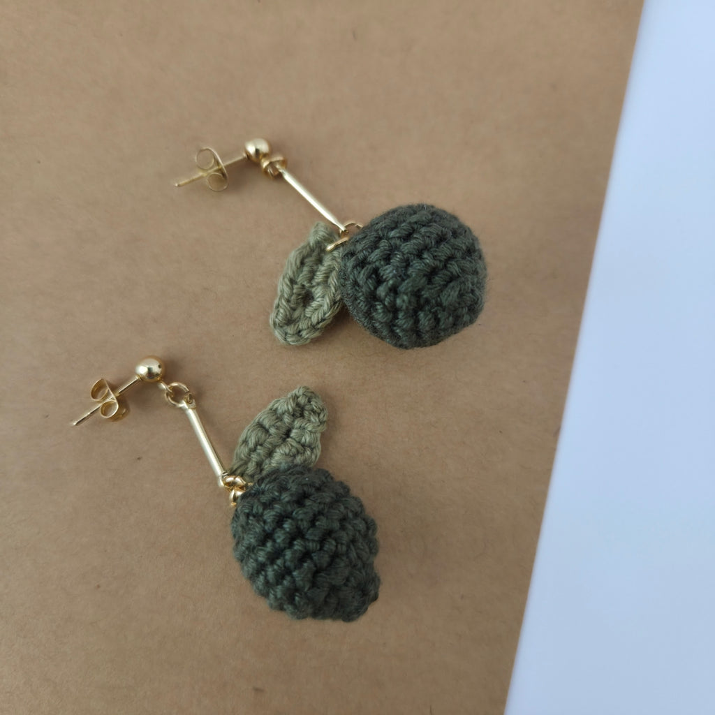 Handmade crochet lime earrings on a brown surface