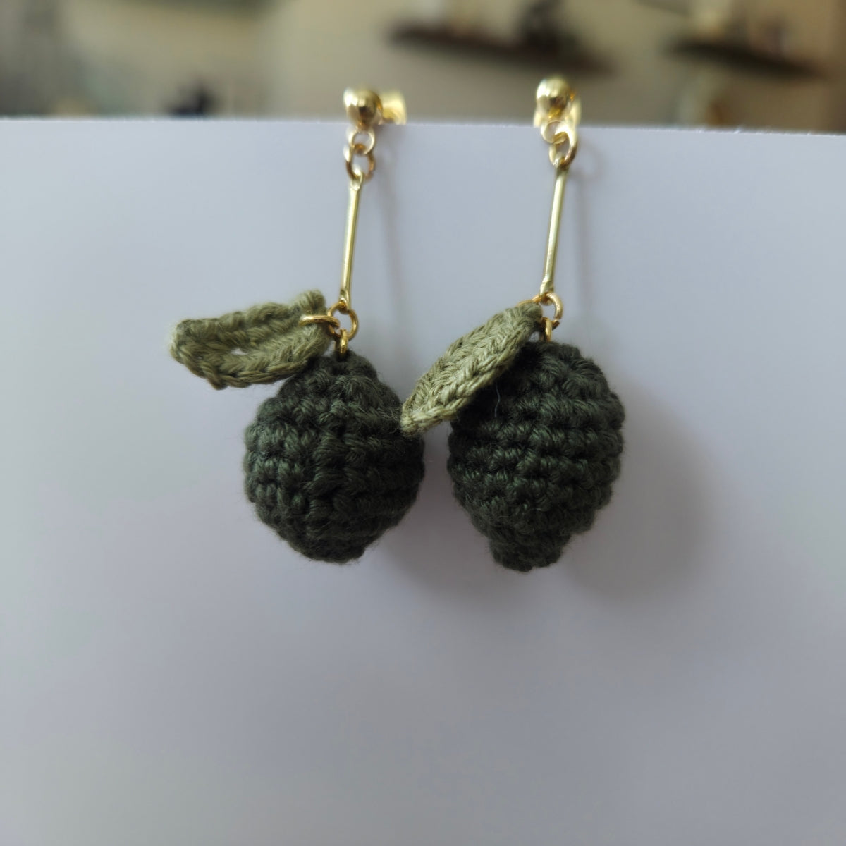 Green lime crocheted earrings with gold hooks on a white background