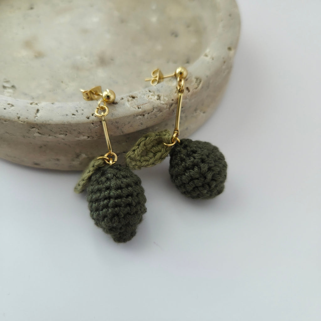Crocheted green lime earrings with gold hooks on a white surface