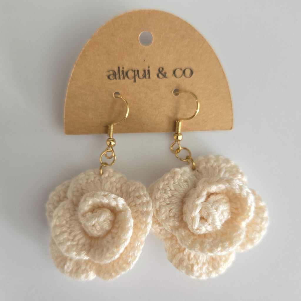 A white flower earring on a card 