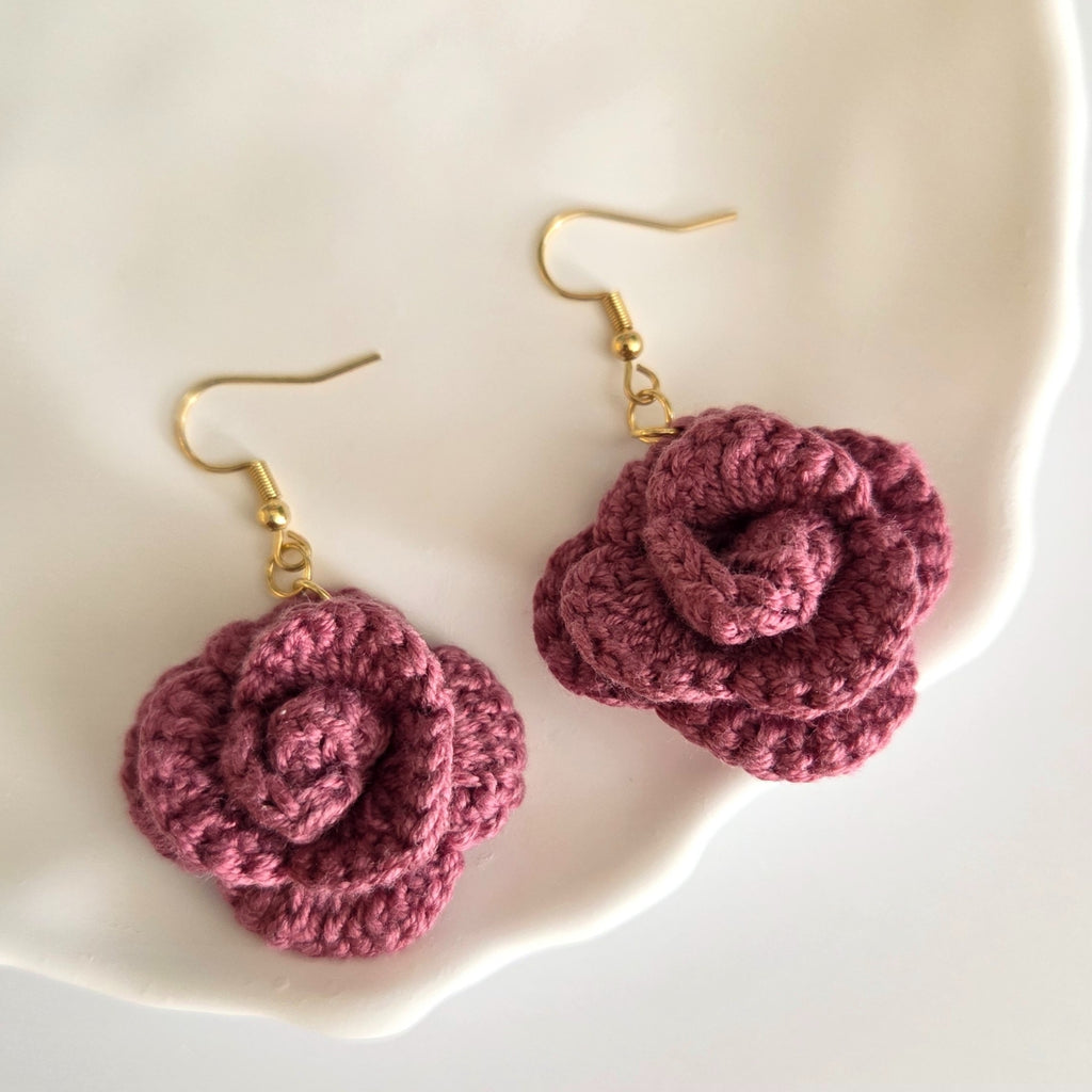 Crochet rose earring on a white plate background
