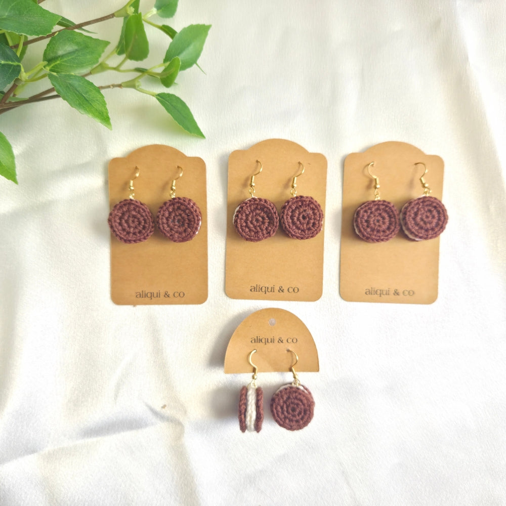 Set of earrings on display with 'aliqui & co' cards on a white background