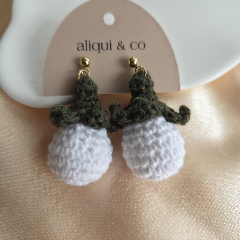 Crocheted earrings with green and white details on a 'aliqui & co' card.