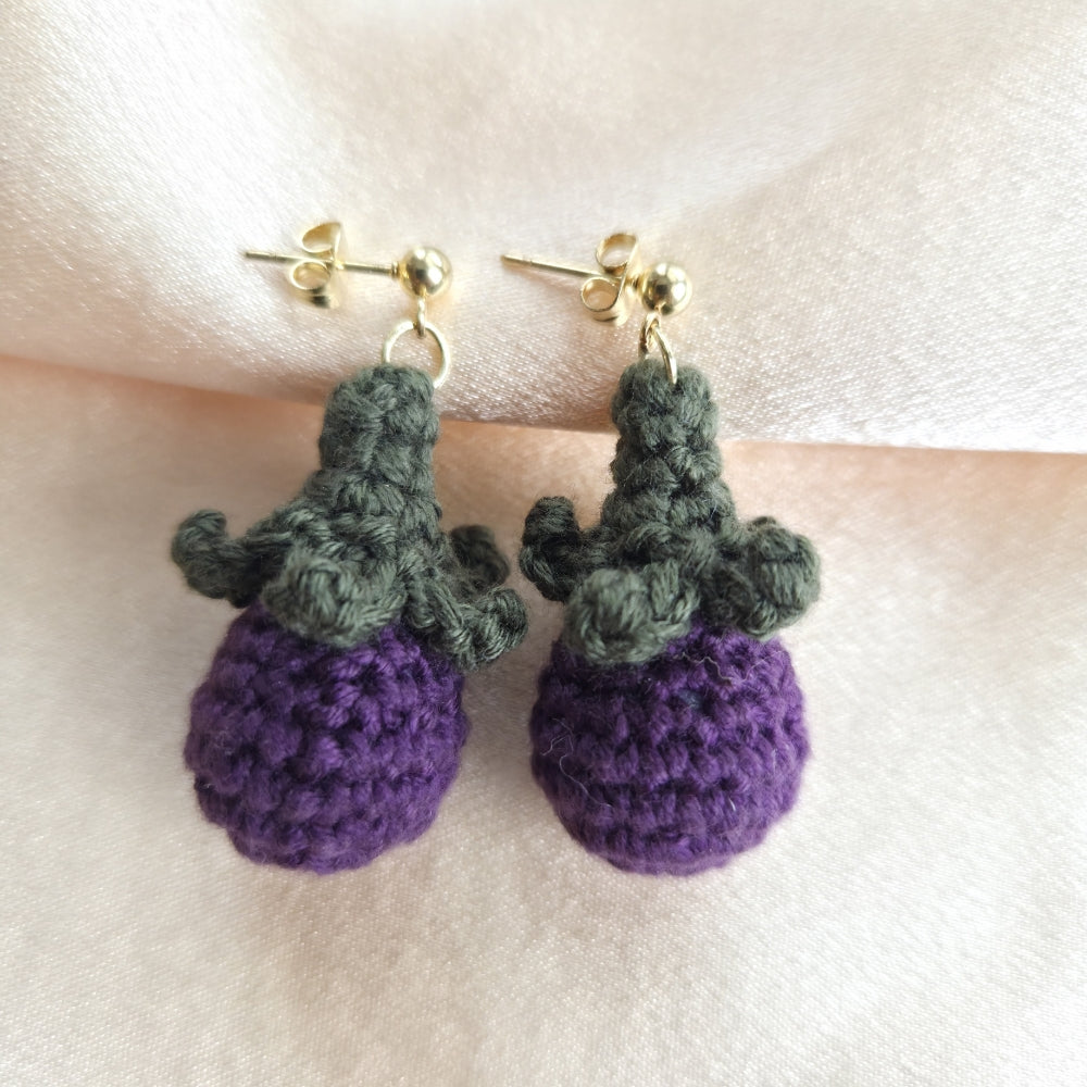 Purple crocheted earrings eggplant in a light background