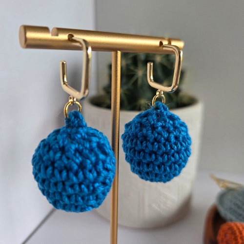 Blue handmade crochet earrings on a gold earring hoops