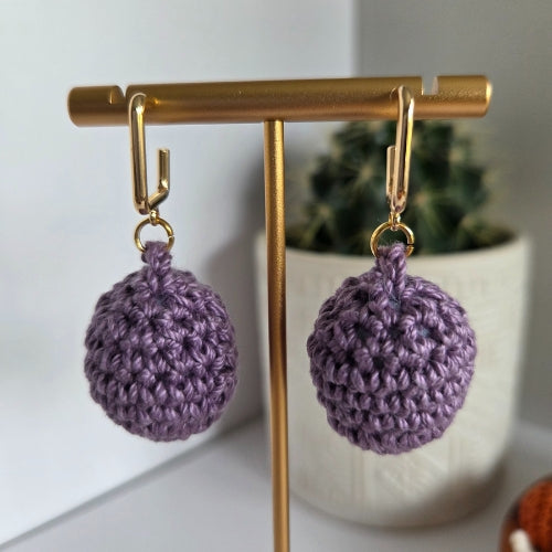 Purple crocheted earrings on a 18k gold-plated earring stud with a blurred background
