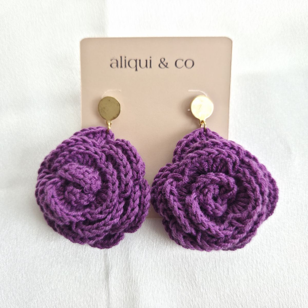 Purple crocheted earrings on a 'aliqui & co' branded card against a white background