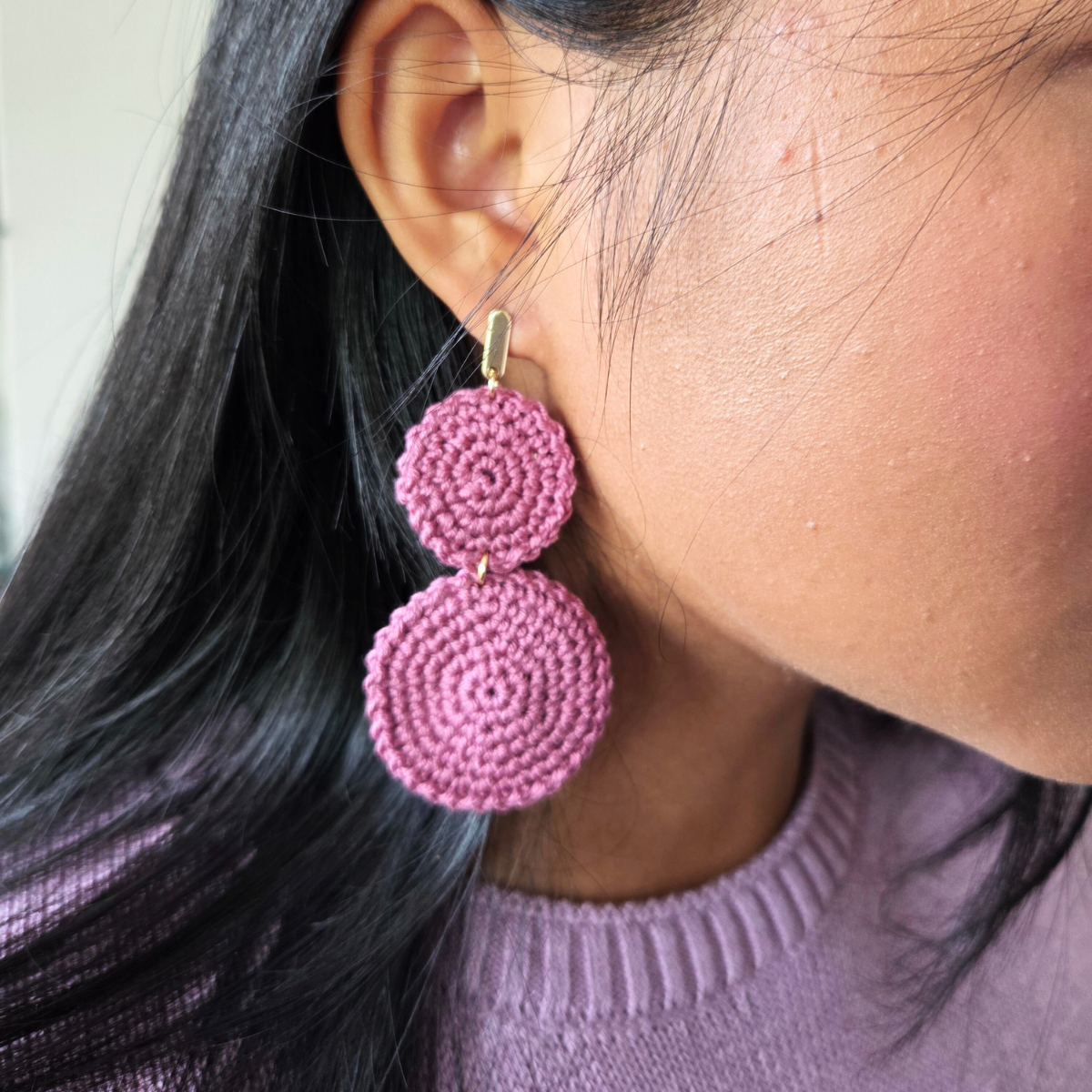 Woman in dusty rose double circle crochet earring with golden stud
